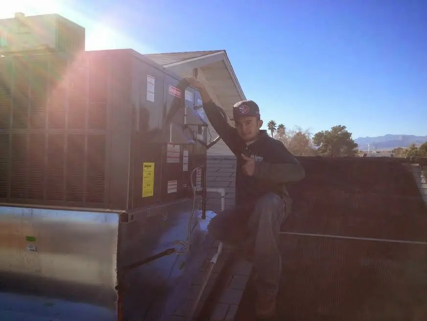 HVAC technician performing HVAC Inspection on a rooftop unit in Wood River